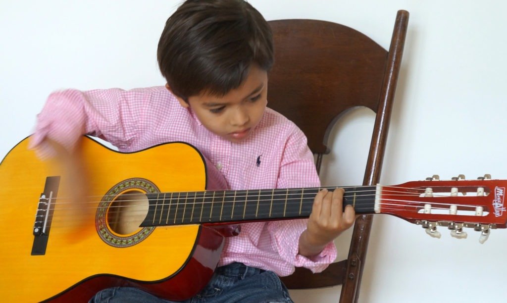 kid-strumming-guitar-lesson