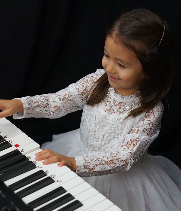 cute girl playing easy kids piano lessons